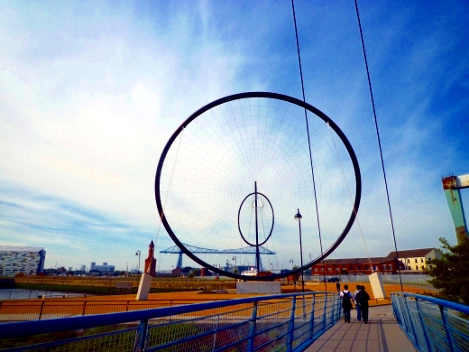 球场旁边的雕塑，是两位艺术家赠送给俱乐部的。后面的蓝色大桥就是米堡的标志“运输大桥”，建于1911年